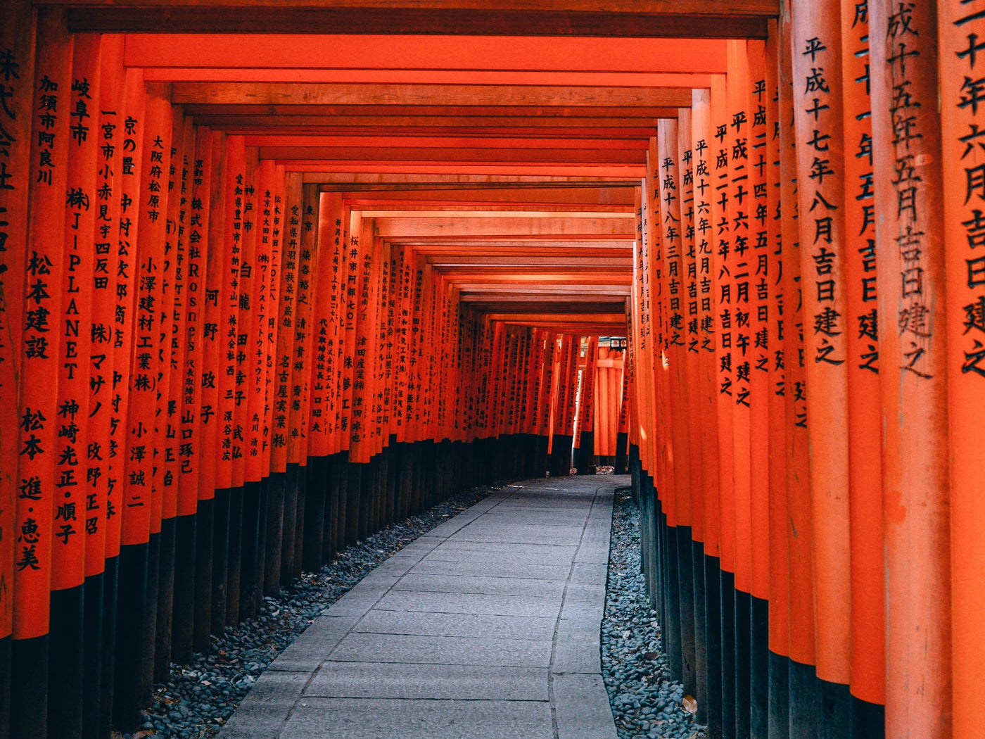 Path through rows of vermilion torii gates in Kyoto