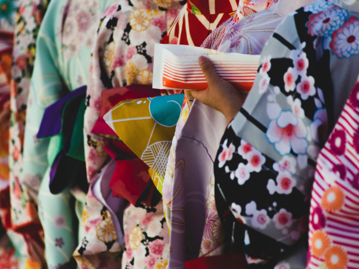 Guest holding a folded fan while wearing a patterned yukata