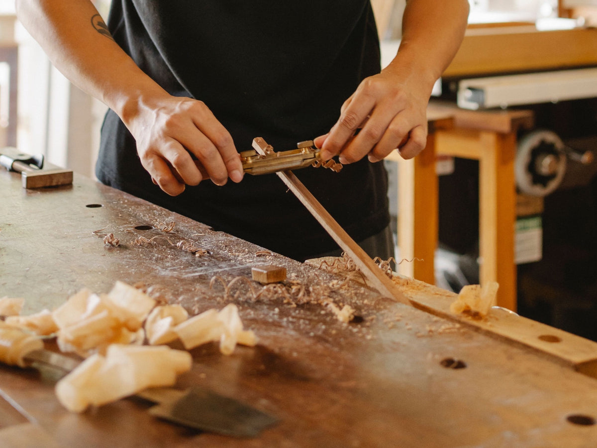 Hands shaping wood during a chopstick-making session in Tokyo