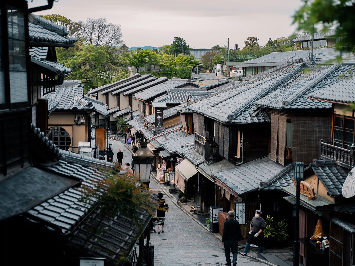Traditional tiled rooftops along a historic street in Kyoto