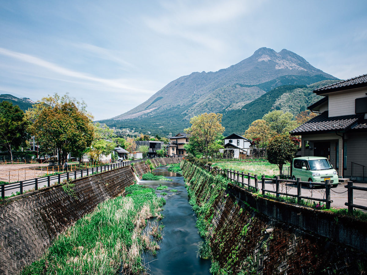 Mountain town with a canal, traditional houses and a peak behind