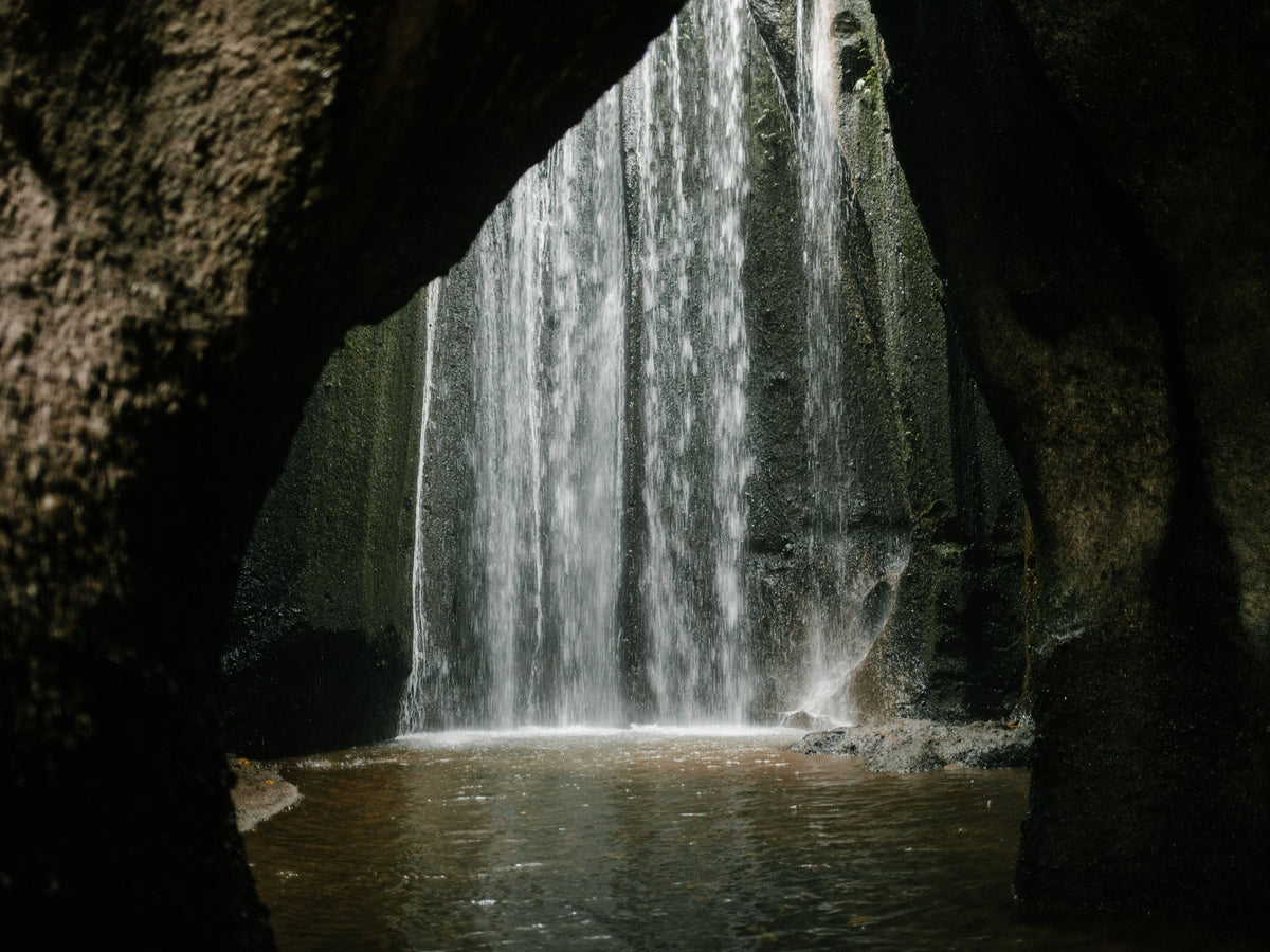 Waterfall framed by dark volcanic rock